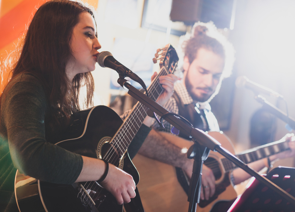 Duet of Guitarists Singing during a Musical Performance.